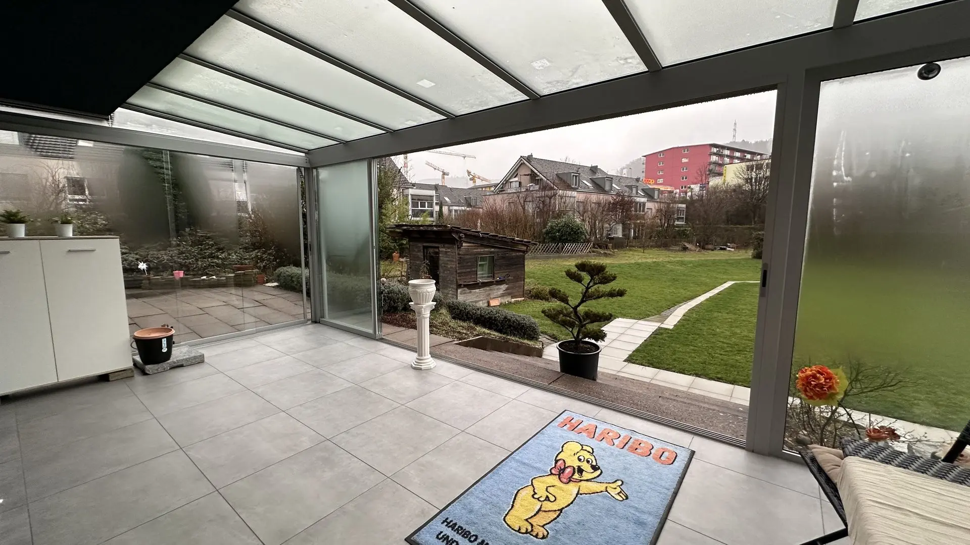 Professionelle Bildoptimierung für individuelle Präsentationen Optimierte Bilddarstellung eines Wintergartens mit Glasdach und Gartenblick für hochwertige Visualisierungen