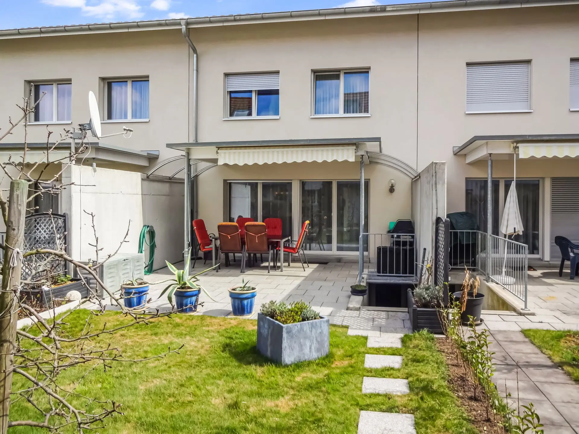 Diskrete und präzise Bildoptimierung für Ihre Immobilienbilder Optimierte Visualisierung eines Reihenhauses mit gepflegtem Garten für überzeugende Präsentationen