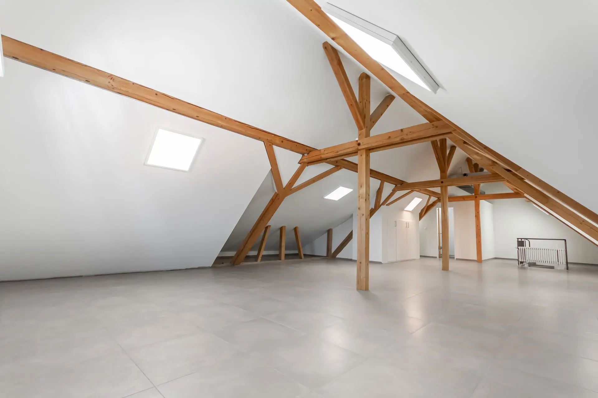 Bildoptimierung für Immobilienfoto – Dachgeschoss mit sichtbaren Holzbalken Optimiertes Foto eines Dachgeschosses mit Holzbalken und weisser Wandgestaltung