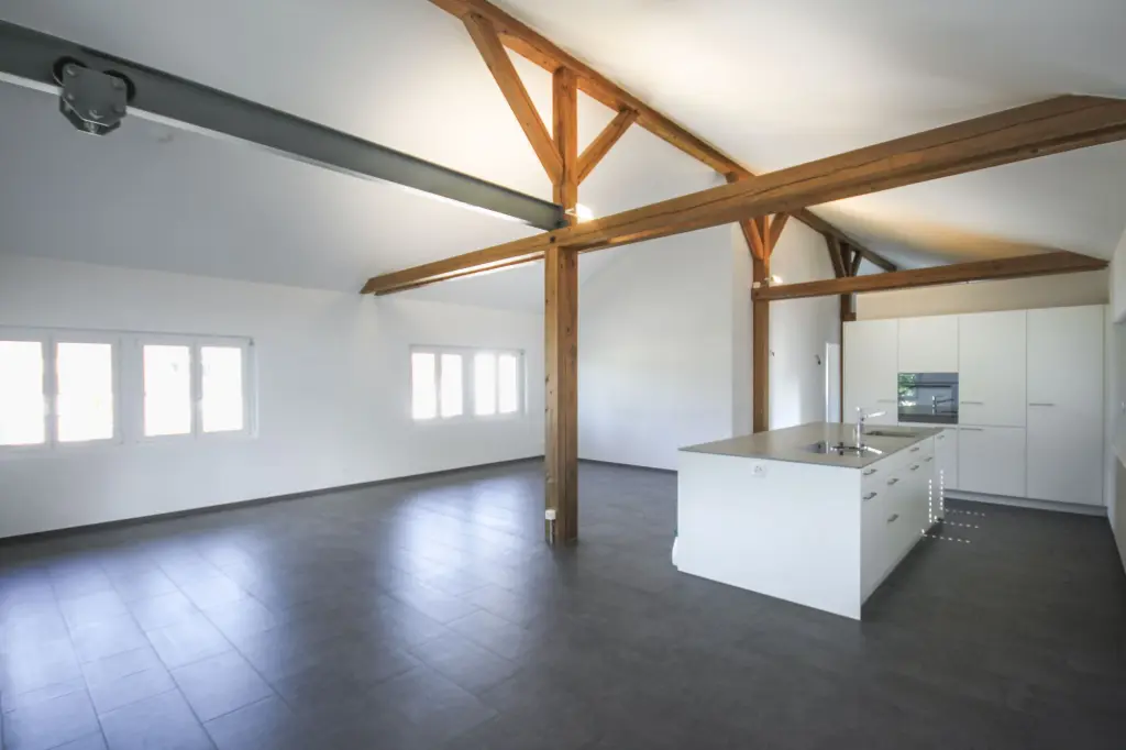Grosszügige Dachwohnung mit Sichtbalken Helle Dachwohnung mit offenem Wohn-Essbereich und sichtbaren Holzbalken