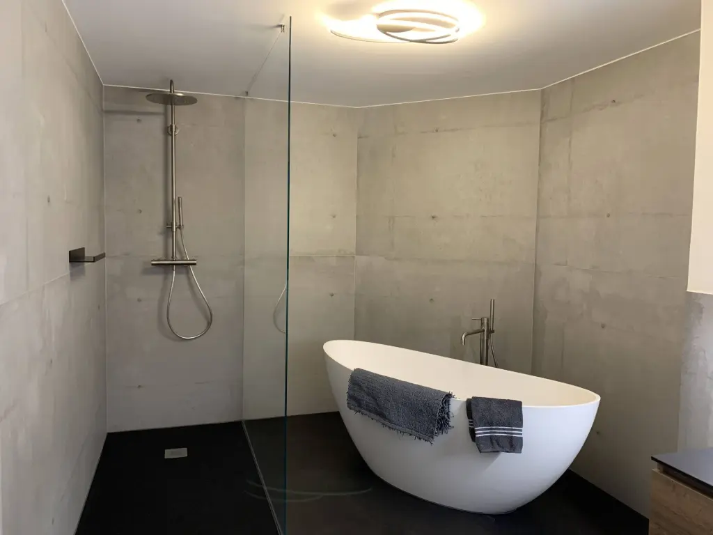 Dusche mit moderner Gestaltung und Glasabtrennung Walk-in Dusche mit grauer Wandverkleidung