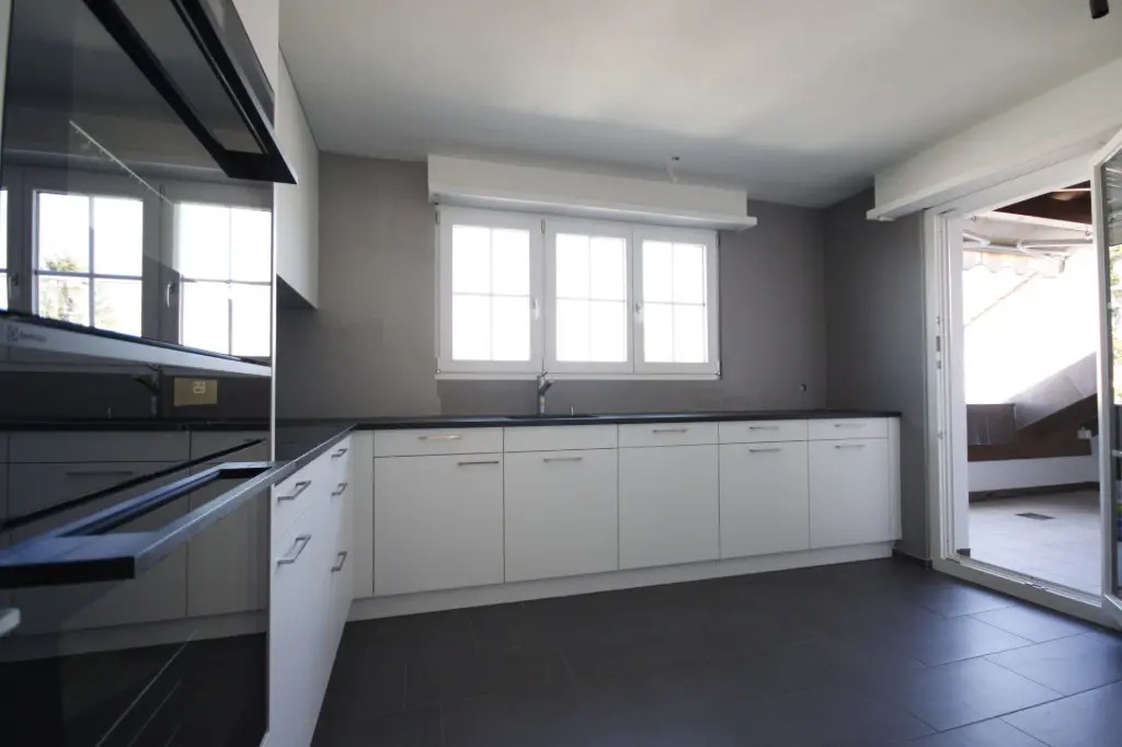 Küche mit weissen Fronten und viel Tageslicht Geräumige Küche mit Fensterfront – funktional und hell