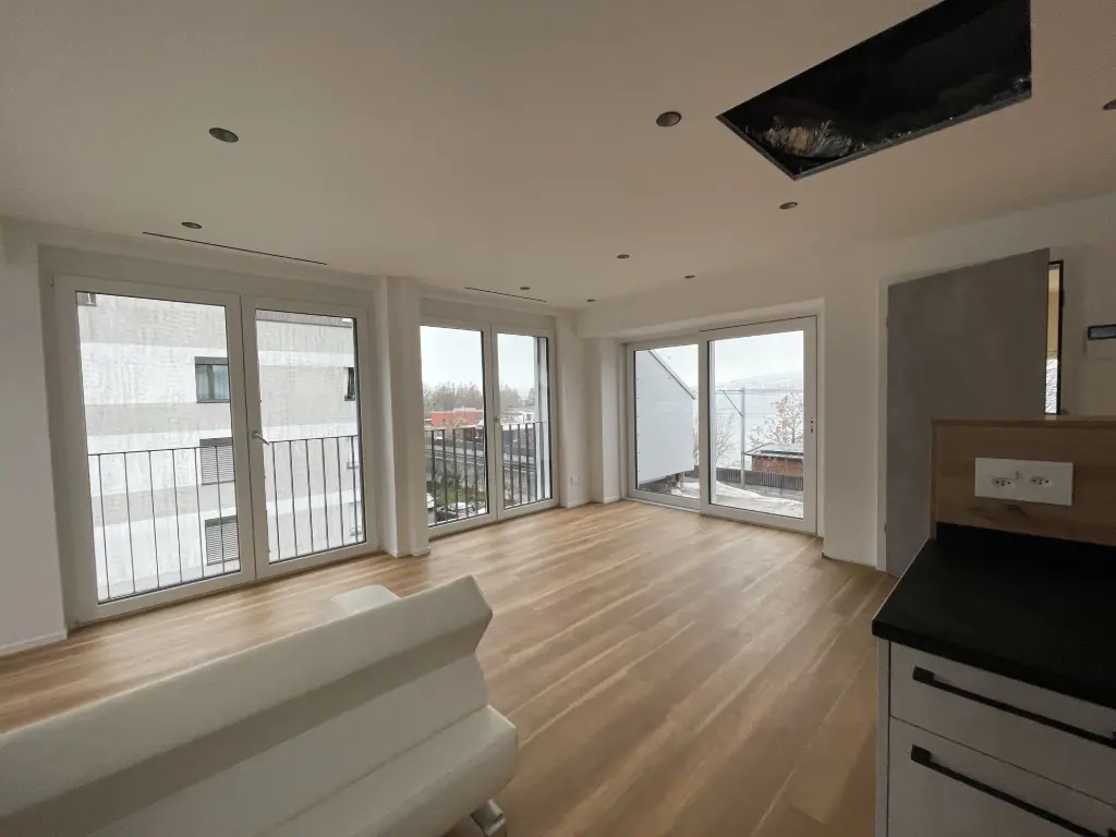 Offenes Wohnzimmer mit Zugang zur Terrasse Wohnbereich mit Parkettboden und grosser Fensterfront