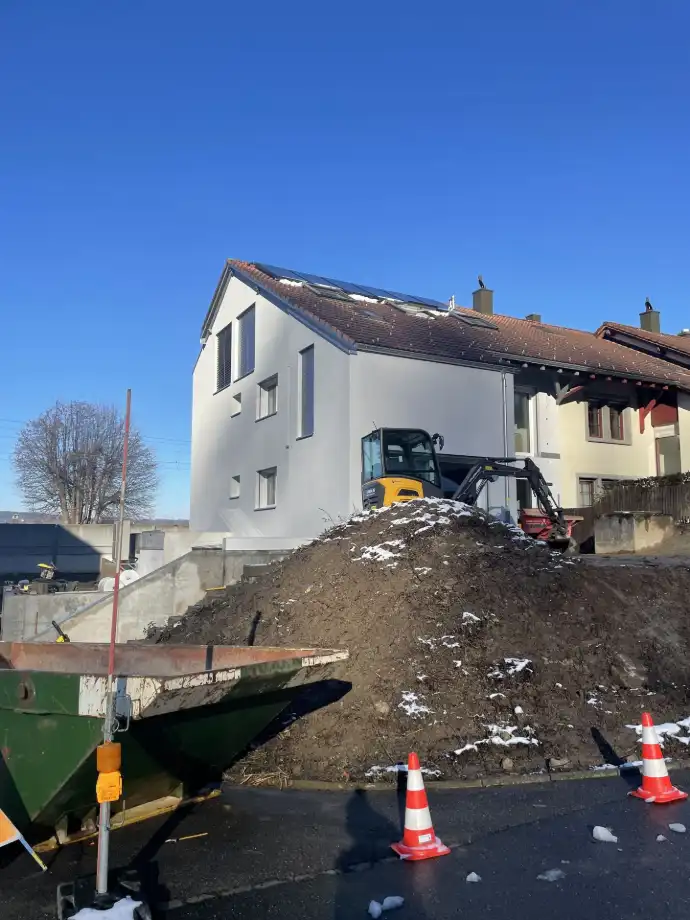 Hausbau in Vorbereitung – Erdarbeiten und Zufahrtsgestaltung Einfamilienhaus in Bauphase mit Bagger und Erdarbeiten