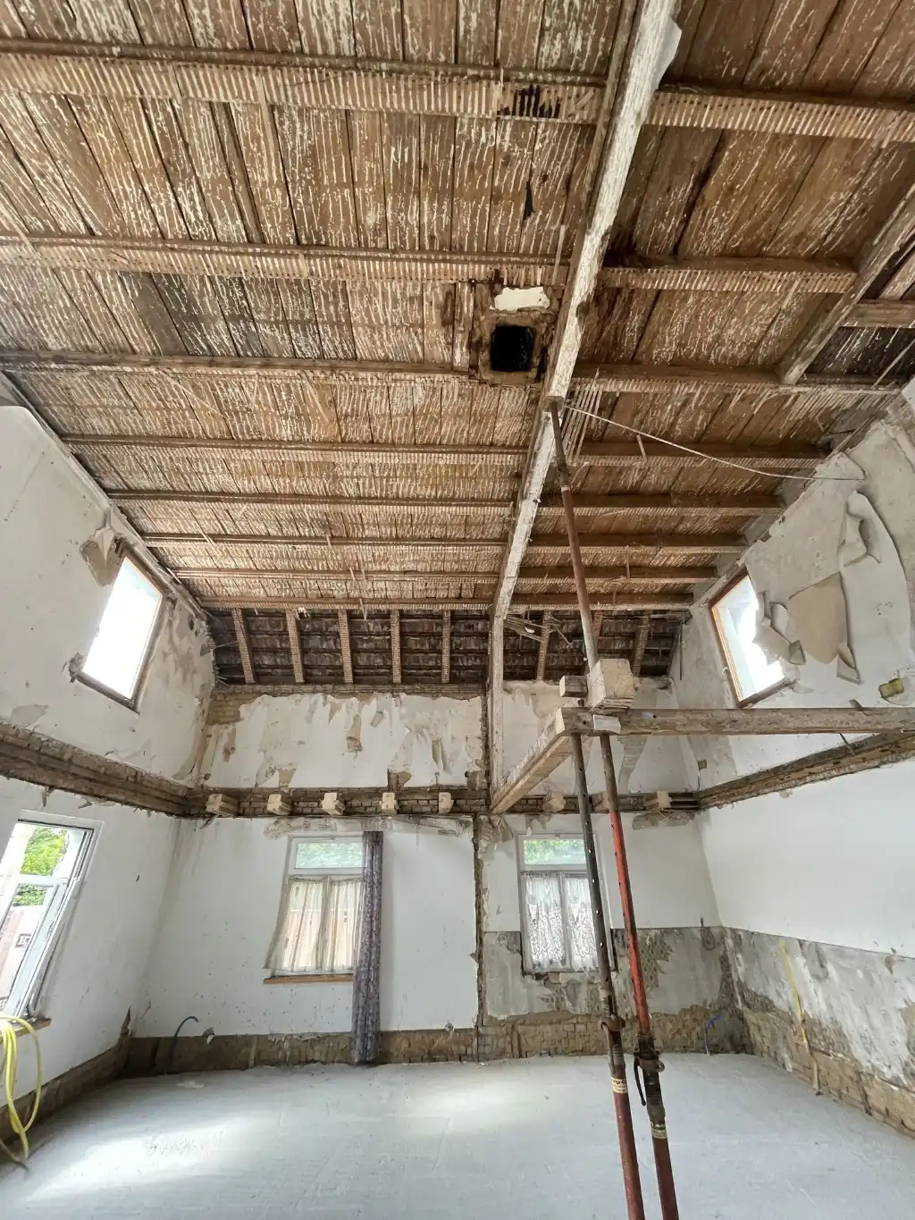 Umbau im Bestand – Raum mit freiliegenden Sparren und Baugerüst Baustelle mit historischer Dachstruktur – Umbau eines Altbaus