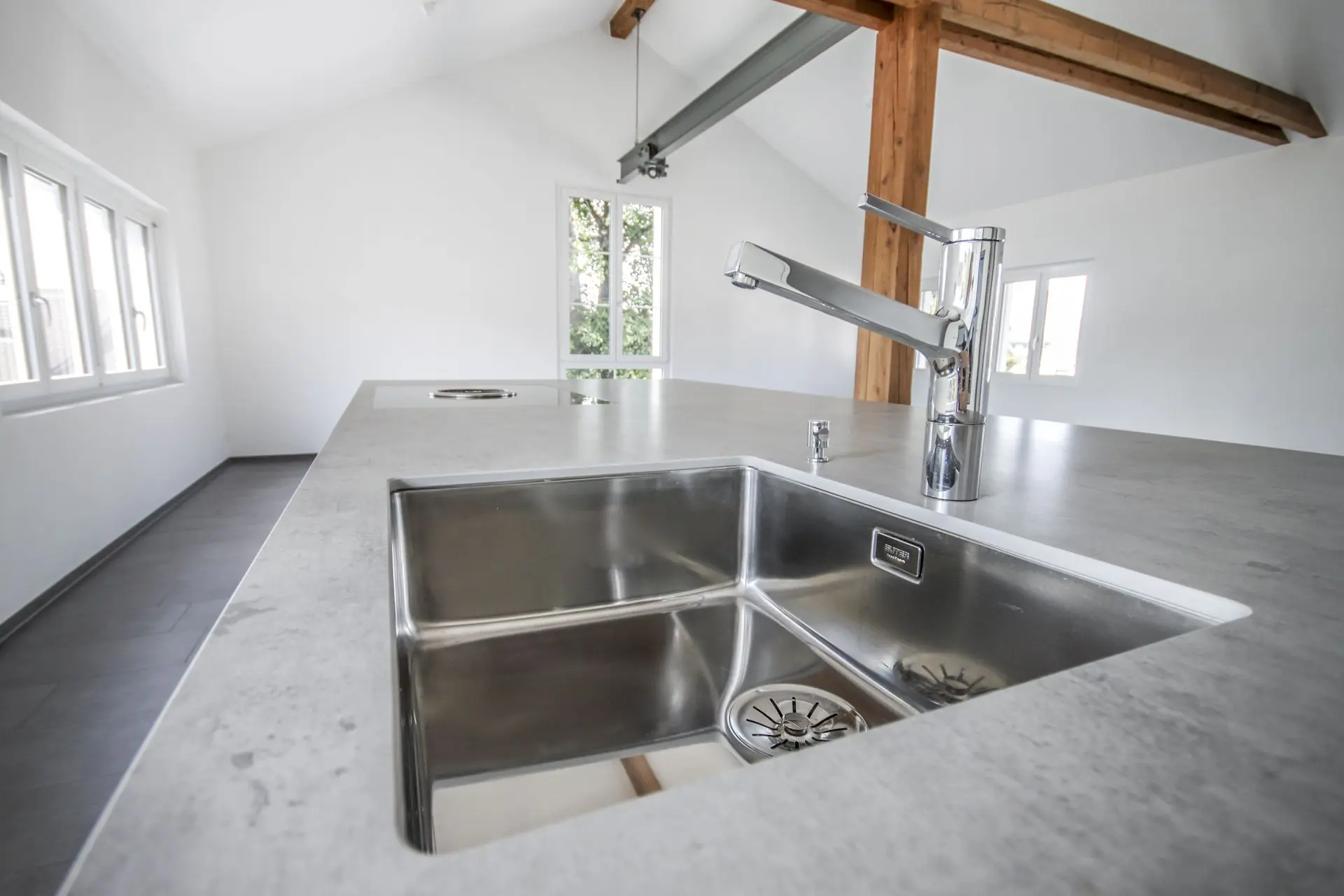 Minimalistische Küche mit Betonboden und weißen Elementen