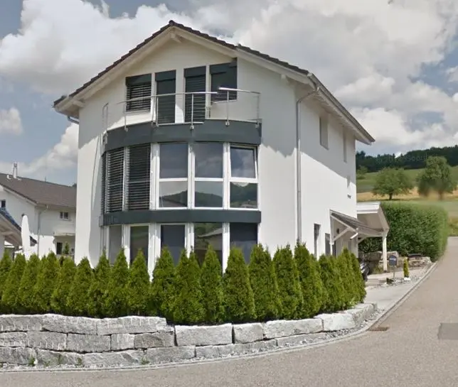 Zweigeschossiges Einfamilienhaus mit halbrunder Fensterfront und Balkon