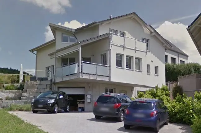 Helles Haus mit mehreren Wohneinheiten, Balkon und gepflasterter Einfahrt