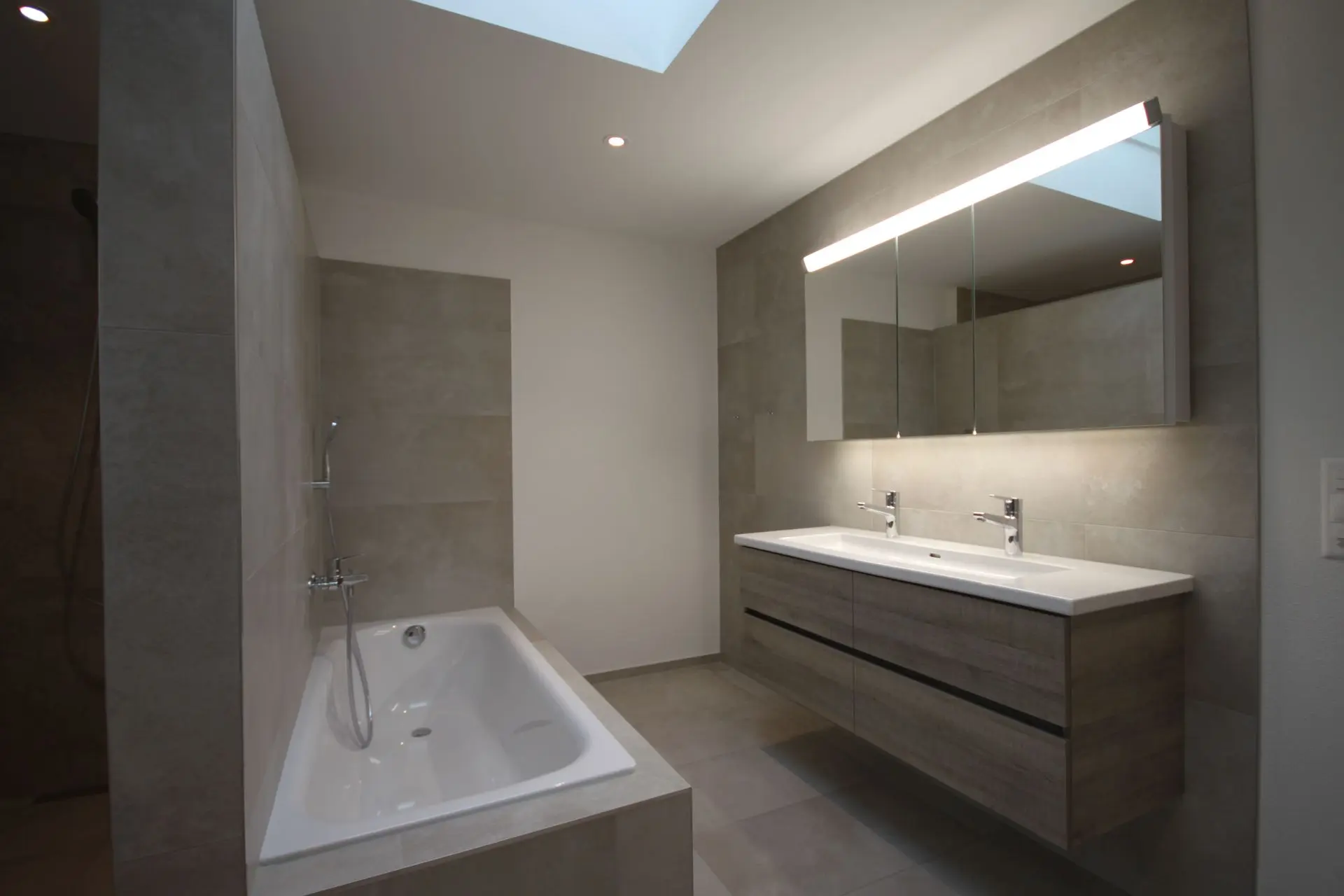 Modernes Bad mit Badewanne, Doppelwaschtisch und grossem Spiegel