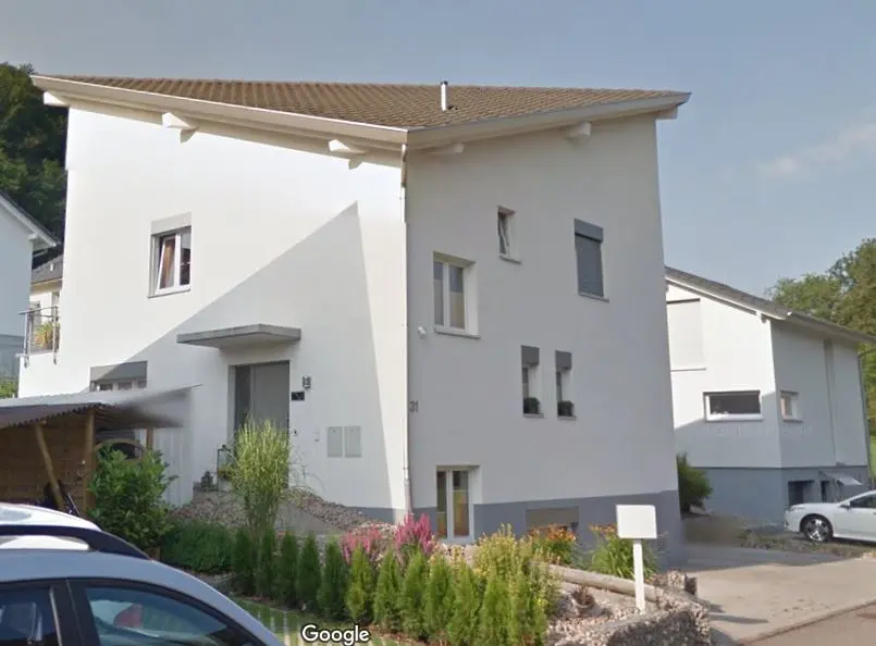 Minimalistisches Neubauhaus mit klaren Linien, Terrasse und grosszügigem Rasen