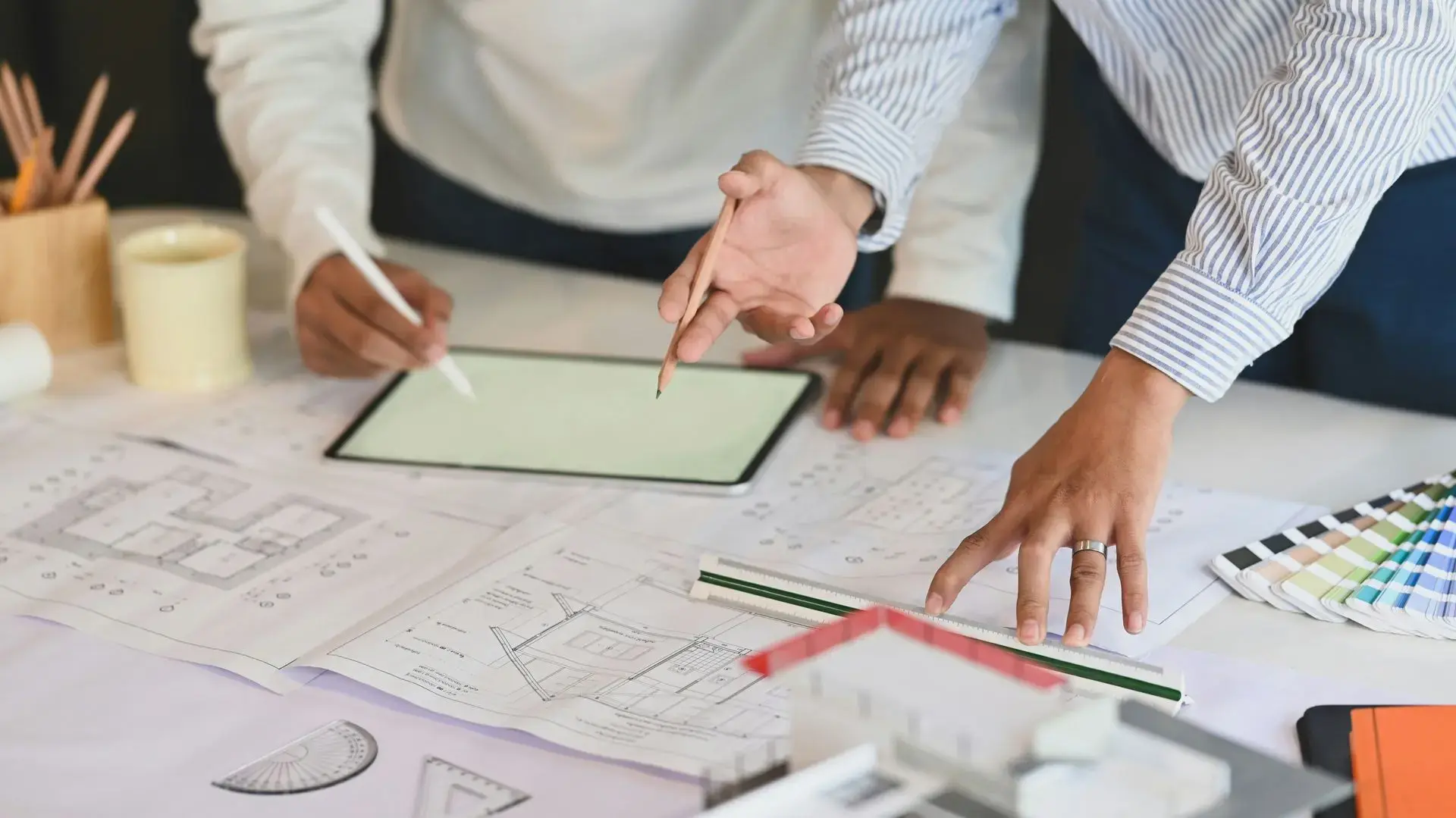 Zwei Personen arbeiten an Architekturplänen – Beginn der Konzeption und Umsetzung