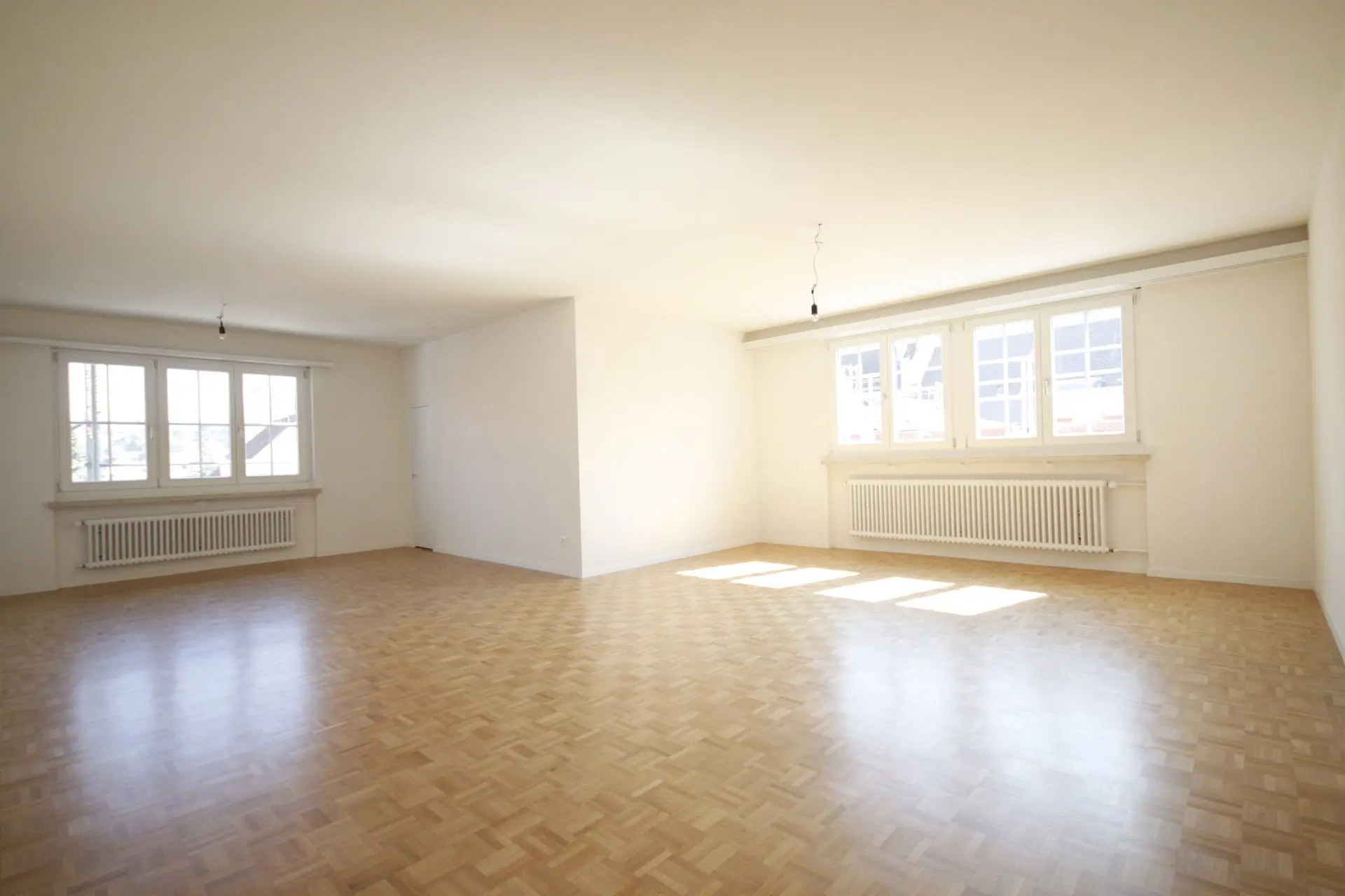 Virtual Staging leerer Wohnraum mit Parkettboden und grossen Fenstern