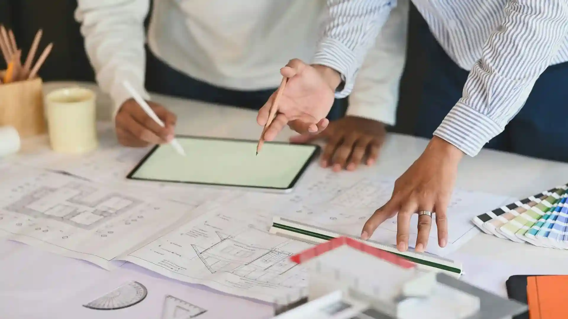 Zwei Personen arbeiten an Architekturplänen – Beginn der Konzeption und Umsetzung